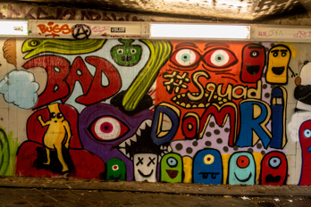 Colorful funny graffiti on tiles in pedestrian underpass 