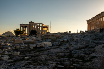 All that remains of the former statue of Athena Promachos is the base in the rocky ground and a few decorative elements. In the background is the Erechtheion on the left and the Parthenon on the right