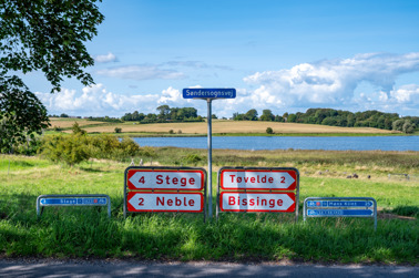 Road signs at a crossroads on the Danish island of Møn near Stege on the lake Stege Nor.