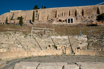 Stage and tiers of the Theatre of Dionysus. In the background the Acropolis rock and in the centre the Corinthian columns above the Choragic Monument.