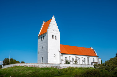 The Fanefjord Church was built in the 13th century and stands prominently on a hill at the eastern end of the Fanefjord of the same name.