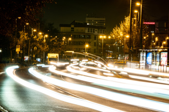 Long exposure image at night. Light trails from moving cars and light poles with starbursts. Office buildings in the background. Carl-Bosch-Straße, Ludwigshafen am Rhein