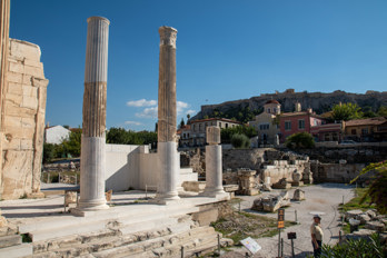 Corinthian columns in the ruins of Hadrian's great library in ancient Athens. In the background the Acropolis Rock and in front of it the Church of the All-Great Taxiarchs.