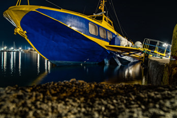 Long exposure of a ferry in the port of Aegina at night.