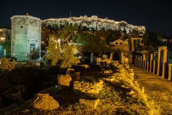 Marble tower on the Roman Agora in Athens at night. The Acropolis in the background.