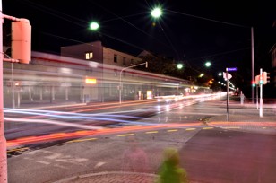 Long exposure of a street intersection with traffic at night.