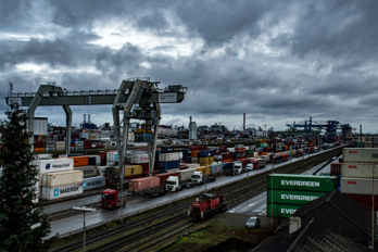 Rails in the foreground. Industrial area to the horizon with dark clouds