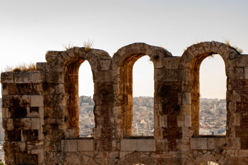 Details of the arches of the Roman Theater Odeon of Herodes Atticus. Houses of Athens in the background.