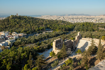 View from the Parthenon to the amphitheatre below. In the background, the Philopappos Monument, the sea of houses in Athens and the Saronic Gulf.