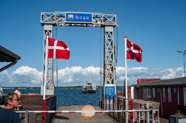 Mooring of the ferry to Bogø in the harbor of Stubbekøbing. The ferry arriving in the background.