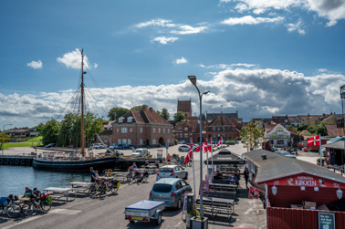 Stubbekøbing harbor. In the foreground a snack bar with tables to sit at. In the background the settlement of Stubbekøbing.