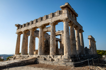 North-eastern view of the Temple of Aphaia. The Doric columns stand on a three-tiered crepis, the above-ground substructure of a Greek temple. On the left is the eastern ramp of carved stone leading up to the crepis.
