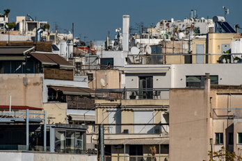 Shot with telephoto lens, the numerous roofs of Athens with many antennas, chimneys, air conditioners, balconies and much more.