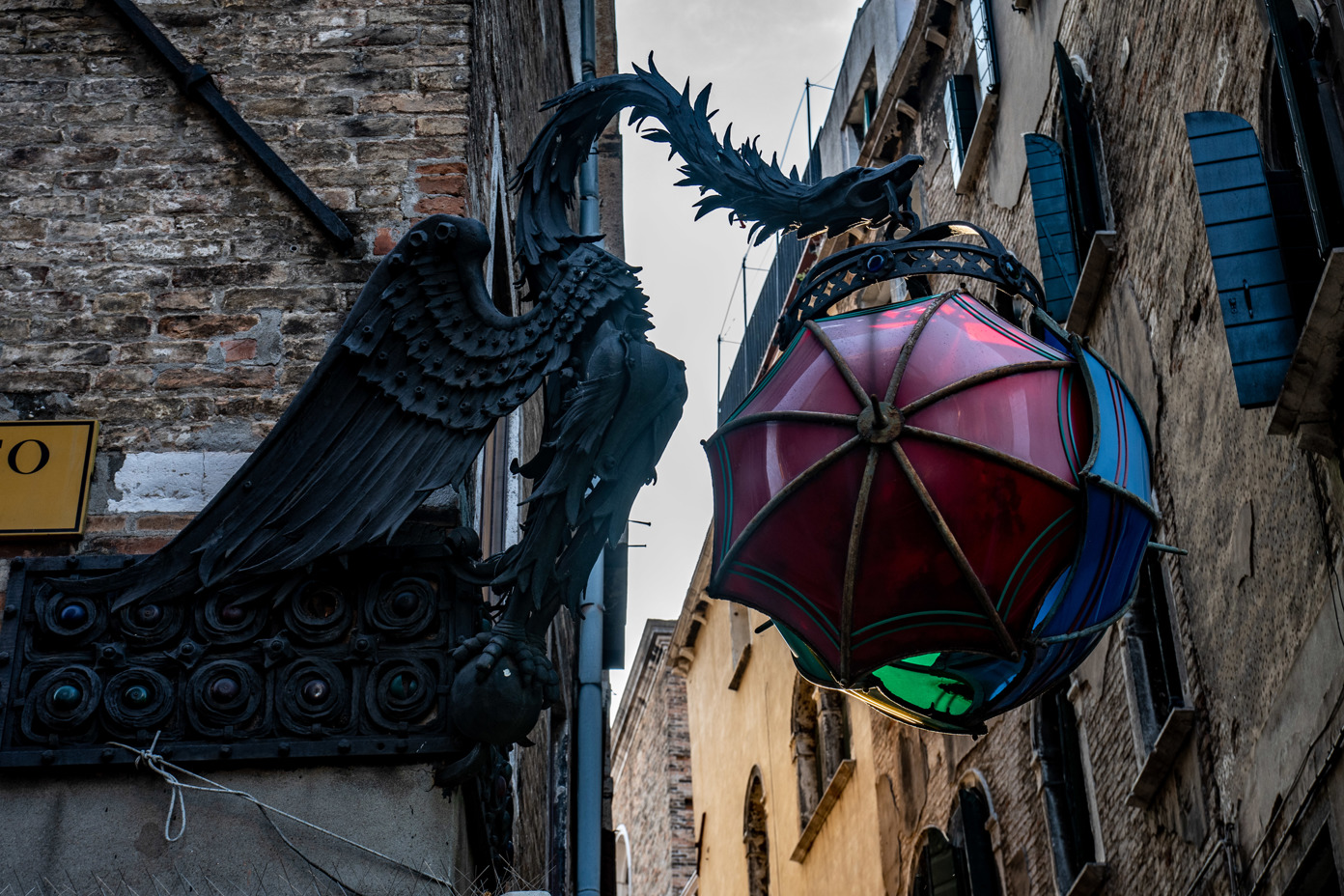 An iron dragon watches over the alleys of the Venetian district of San Marko with an umbrella lamp
Campo S. Salvador